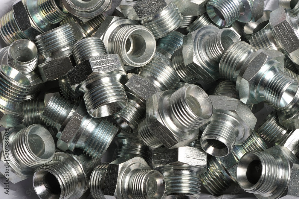 a pile of screws and bolts and connectors for hydraulic pipes: Various steel nuts and bolts a pile of screws and bolts and connectors for hydraulic pipes: Various steel nuts and bolts