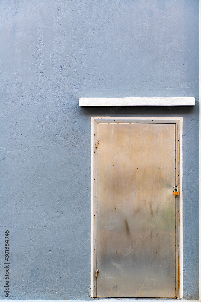 Door steel In the gray wall with old rust are suitable for use as the background is made of the props, idea copy space