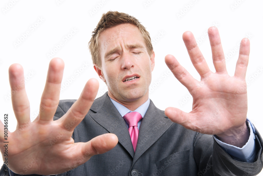 Lost businessman with eyes closed holding hands out to feel his way against a white background Lost businessman with eyes closed holding hands out to feel his way against a white background