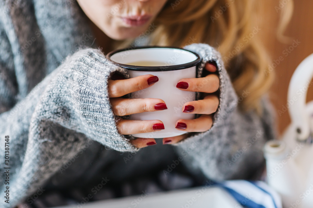 a warm tea to heat a cold winter. The girl is holding herbal tea. a cup of linden tea a warm tea to heat a cold winter. The girl is holding herbal tea. a cup of linden tea
