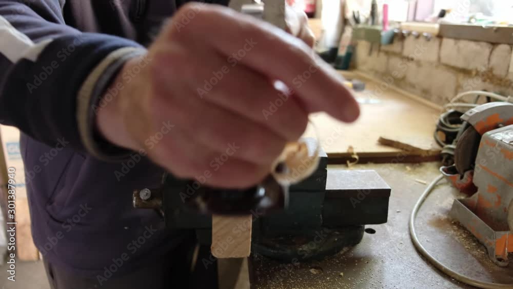 Woodworker hand planing plank in vice - extreme closeup with shallow focus Woodworker hand planing plank in vice - extreme closeup with shallow focus