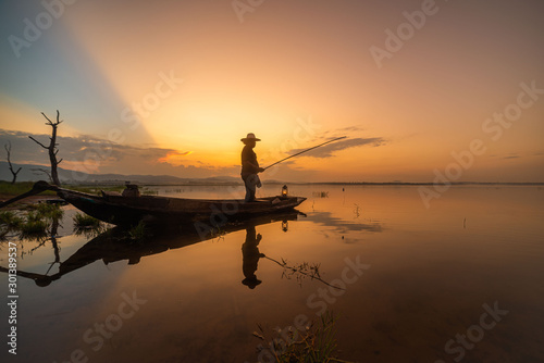 Slika na platnu Picture of Asian fishermen on a wooden boat Thai fishermen catch fresh water fis