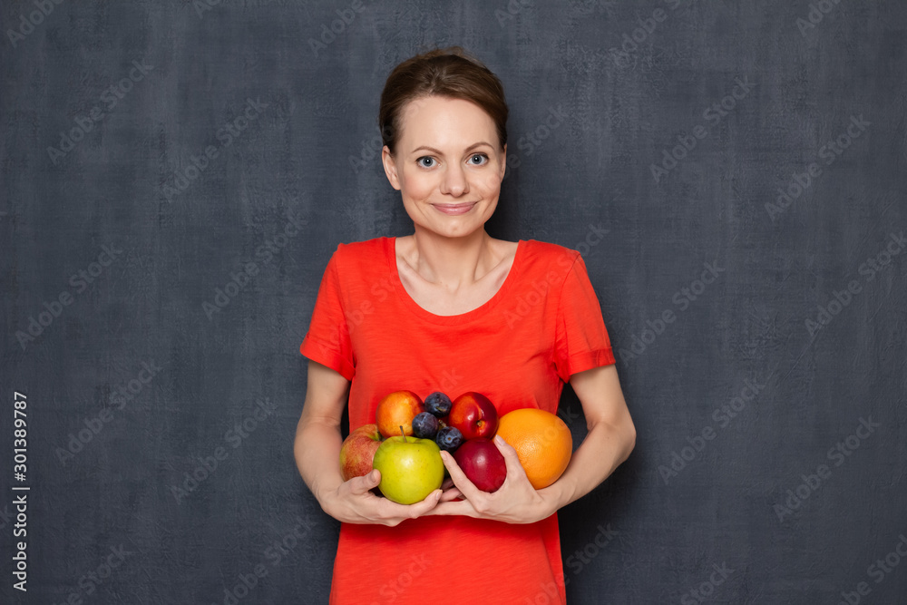 Portrait of happy young woman holding ripe fresh fruits in hands Portrait of happy young woman holding ripe fresh fruits in hands