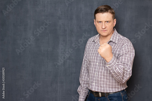 Obraz na plátně Portrait of angry irritated man raising hand with clenched fist