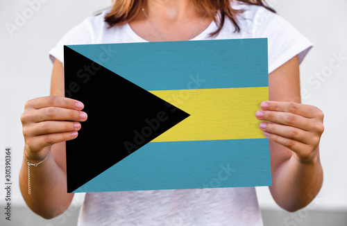 woman holds flag of Bahamas on paper sheet