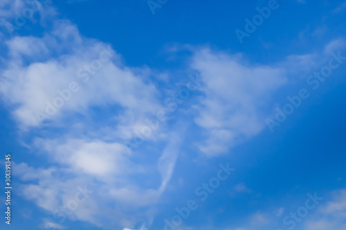 Beautiful white clouds on a background of blue sky. Defocused image for design.