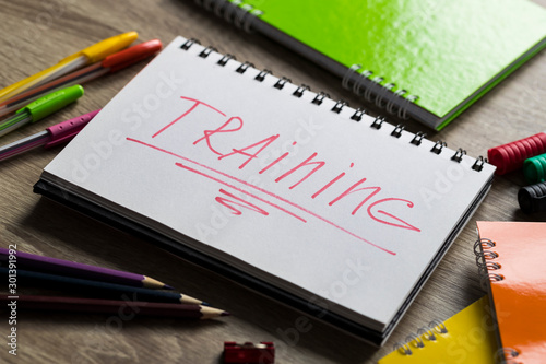 Text on notepad training near stationery tools