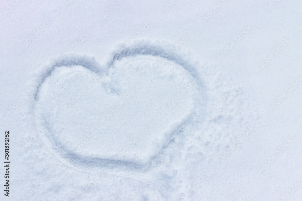 Snowy heart on the winter surface. Big cold heart painted in the snow Snowy heart on the winter surface. Big cold heart painted in the snow