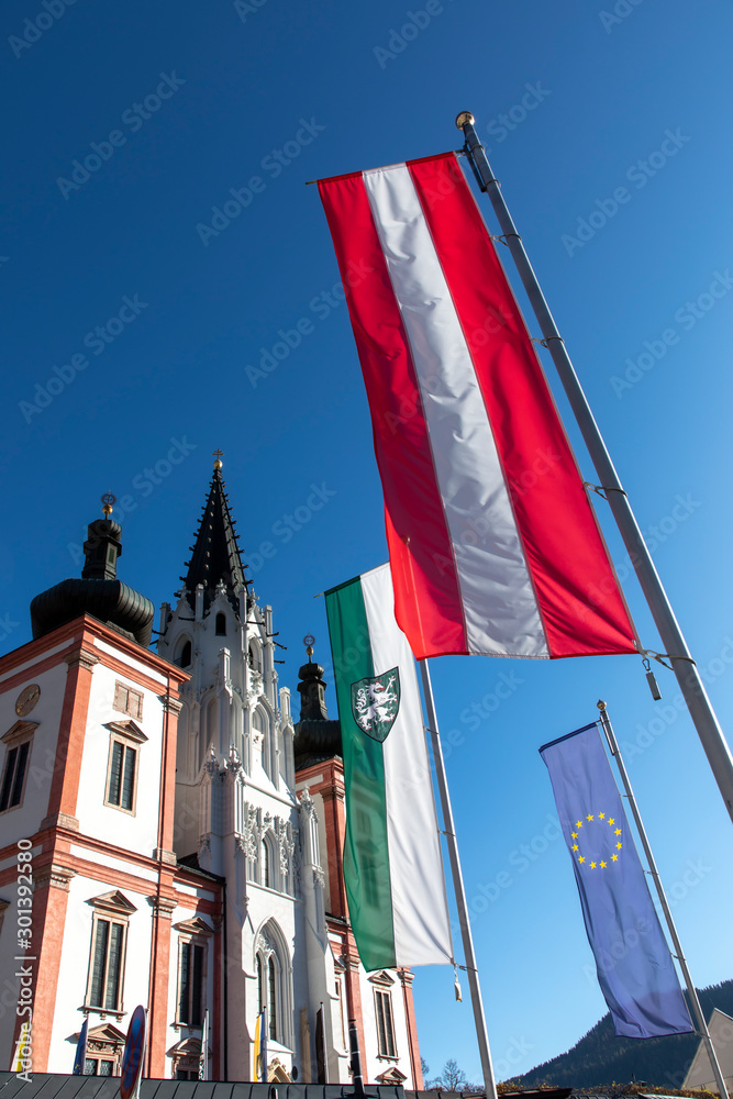 basilica mariazell in austria with flags of styria,austria and european union