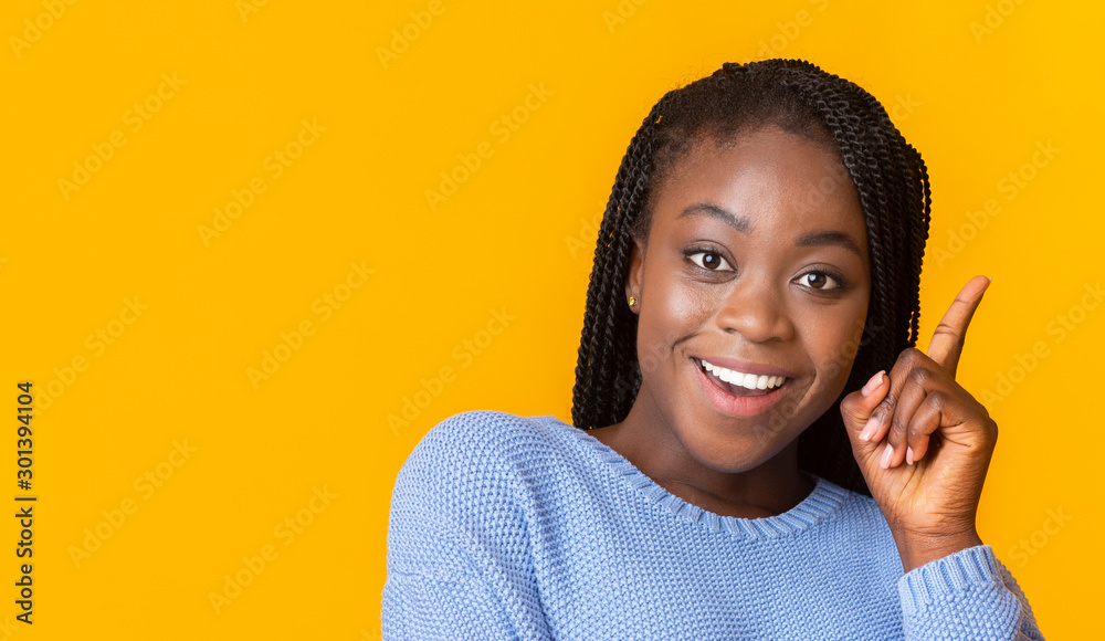 Close up of cheerful black girl raising finger up Close up of cheerful black girl raising finger up
