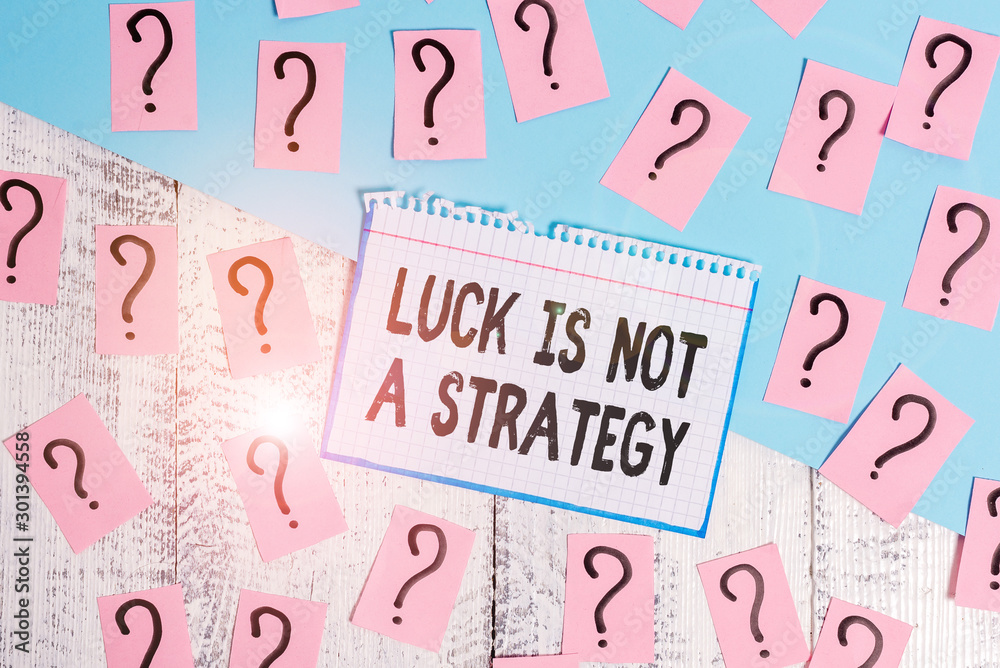 Writing note showing Luck Is Not A Strategy. Business concept for it is not being Lucky when planned intentionally Scribbled and crumbling papers with thick cardboard above wooden table