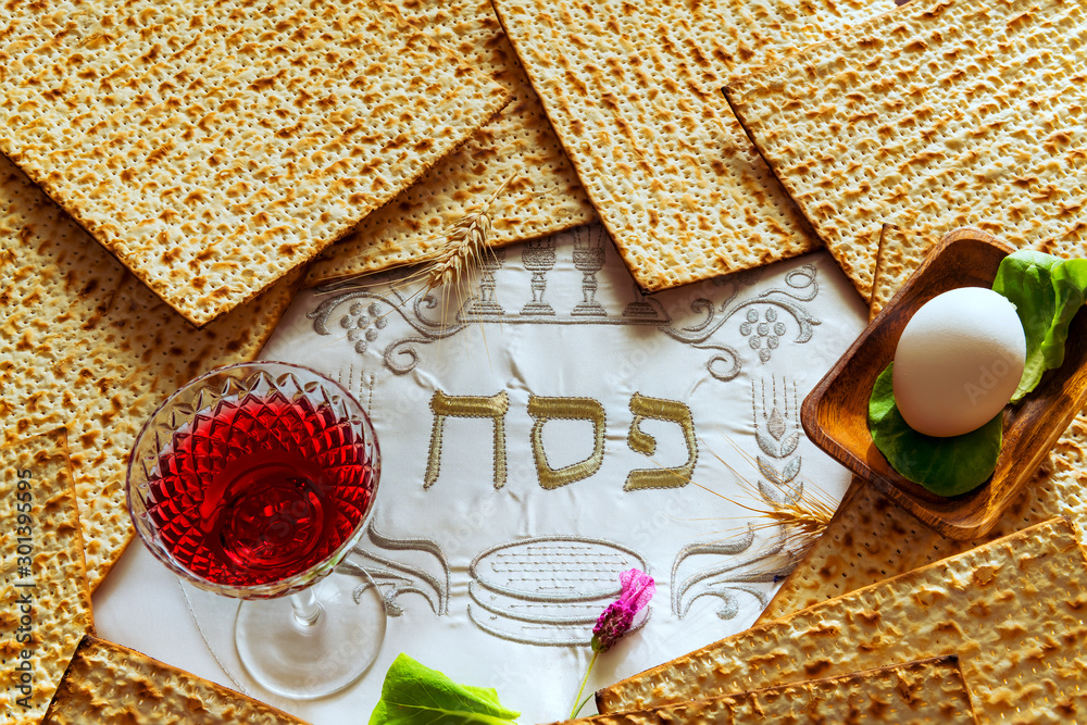 Unleavened bread food - matzah and glass of red wine for Jewish Passover  Holiday. Serviette with written by three Hebrew letters, in English  translation of the letters means Jewish Passover Stock Photo