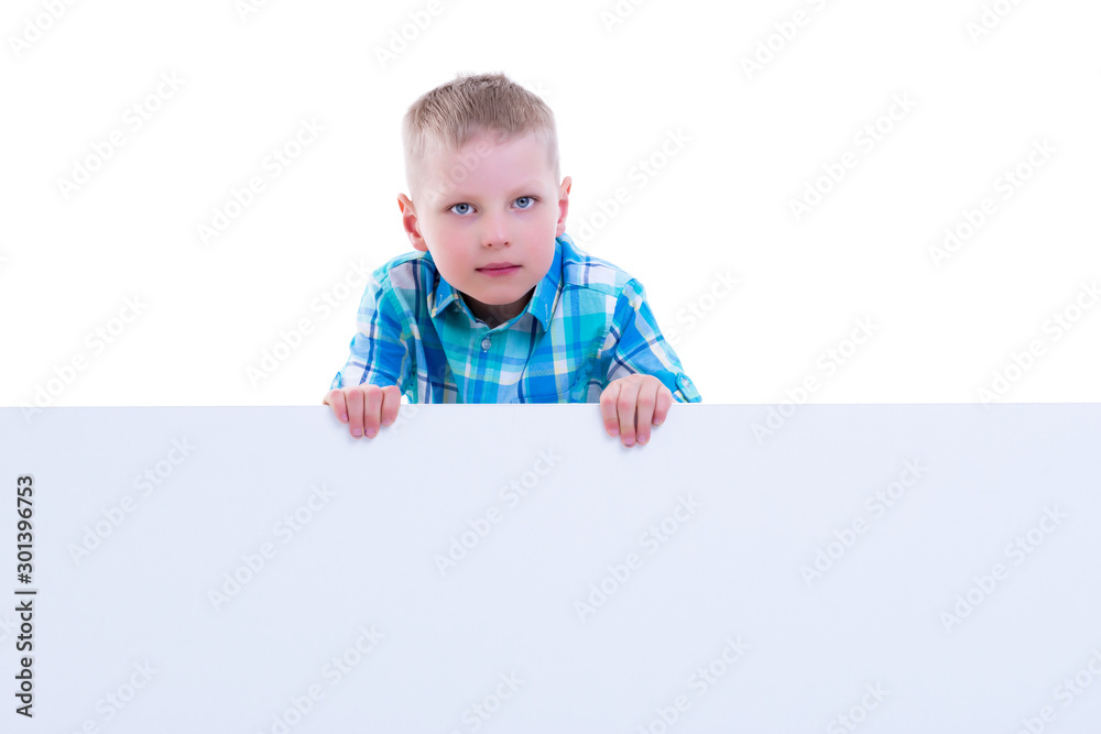 A little boy is looking from behind an empty banner. A little boy is looking from behind an empty banner.