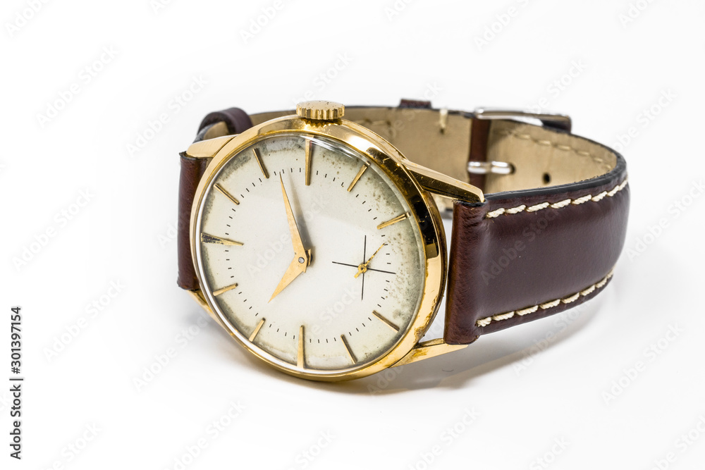 An old gold mechanical wristwatch with manual winding. Antique watch ruined by time, with scratches and mildew stains, rust, oxidation. Leather strap (band). Vintage clock. Spend time. An old gold mechanical wristwatch with manual winding. Antique watch ruined by time, with scratches and mildew stains, rust, oxidation. Leather strap (band). Vintage clock. Spend time.