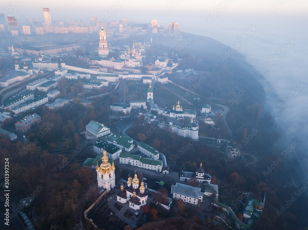 Aerial view Kyiv Pechersk Lavra churches on hills from above with morning fog, Ukraine