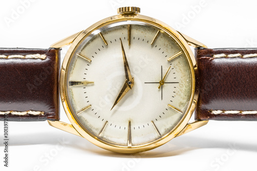 An old gold mechanical wristwatch with manual winding. Antique watch ruined by time, with scratches and mildew stains, rust, oxidation. Leather strap (band). Vintage clock. Spend time.