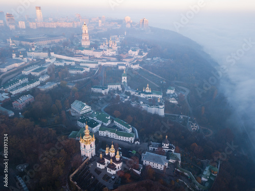 Aerial view Kyiv Pechersk Lavra churches on hills from above with morning fog, Ukraine