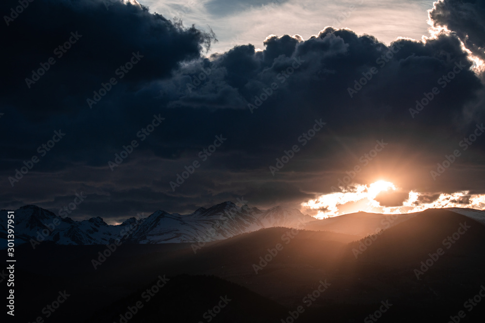 Sunlight leaking through clouds over the Rocky Mountains