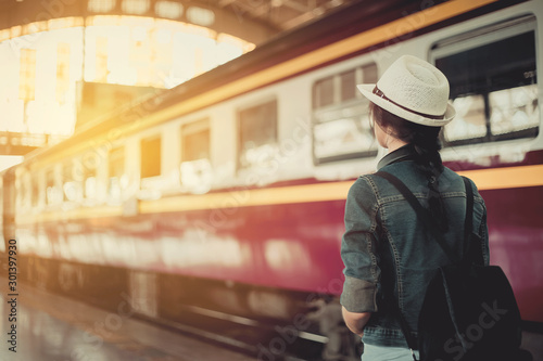 Woman travel tourists traveling with a backpack at the train station Concepts of life and tourism