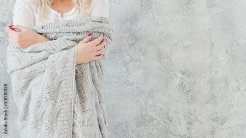 Vulnerable, sensitive female nature. Woman in gray warm handmade knitted blanket. photo