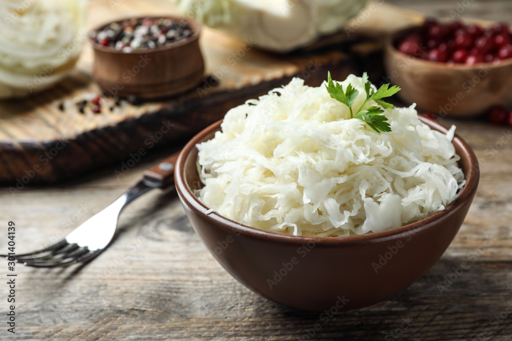Tasty fermented cabbage on wooden table, closeup Tasty fermented cabbage on wooden table, closeup