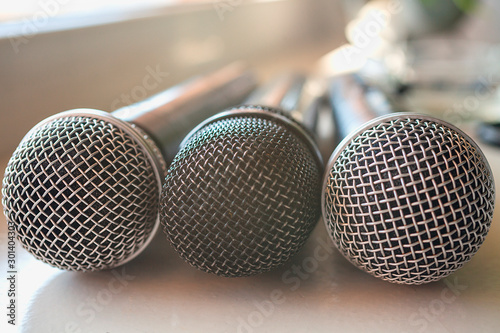 Three wired microphone for vocals on a table. Simple journalism concept