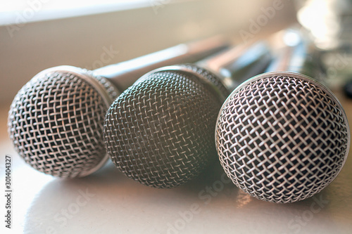 Three wired microphone for vocals on a table. Simple journalism concept