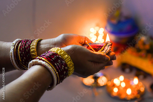 woman hands holding earthen oil lamp to celebrate Diwali