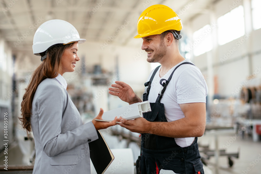 Architect and worker working on project. Colleagues discussing work in factory. Architect and worker working on project. Colleagues discussing work in factory.