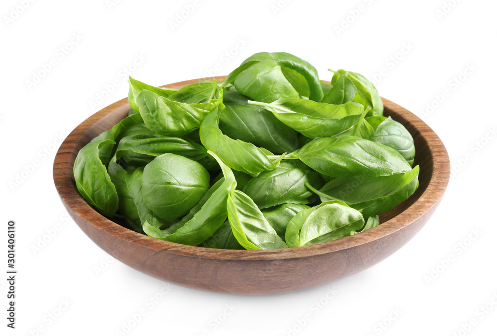 Fresh basil leaves in wooden bowl isolated on white Fresh basil leaves in wooden bowl isolated on white