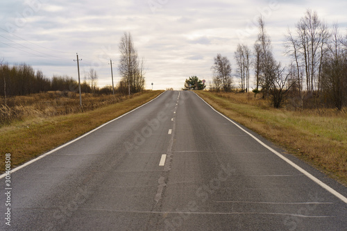 Photography of Russian asphalt road in countryside. Autumn landscape in Moscow region. Concepts of travel mood.