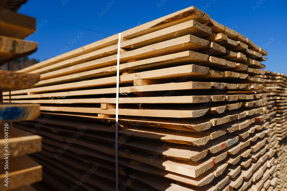 Wood timber in the sawmill. Piles of wooden boards in the sawmill. Wood timber in the sawmill. Piles of wooden boards in the sawmill.