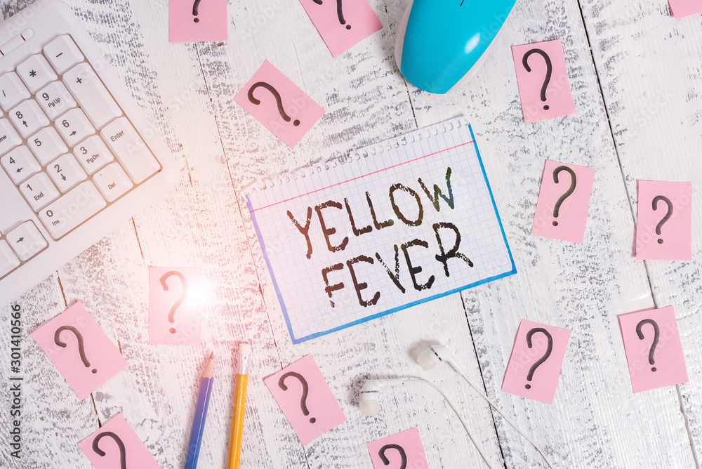 Conceptual hand writing showing Yellow Fever. Concept meaning tropical virus disease affecting the liver and kidneys Writing tools and scribbled paper on top of the wooden table Conceptual hand writing showing Yellow Fever. Concept meaning tropical virus disease affecting the liver and kidneys Writing tools and scribbled paper on top of the wooden table