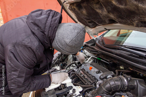 the car mechanic is engaged in repair of cars repair oil change change of wheels polishing of a body