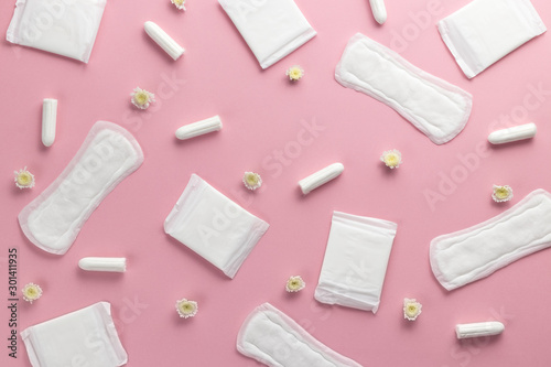 Tampons, feminine sanitary pads on a pink background. Hygienic care on critical days. menstrual cycle. Caring for women's health. Monthly protection. Flat lay, top view, copy space.