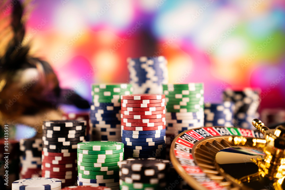Casino theme.  Gambling games. Roulette and poker chips on a colorful bokeh background.