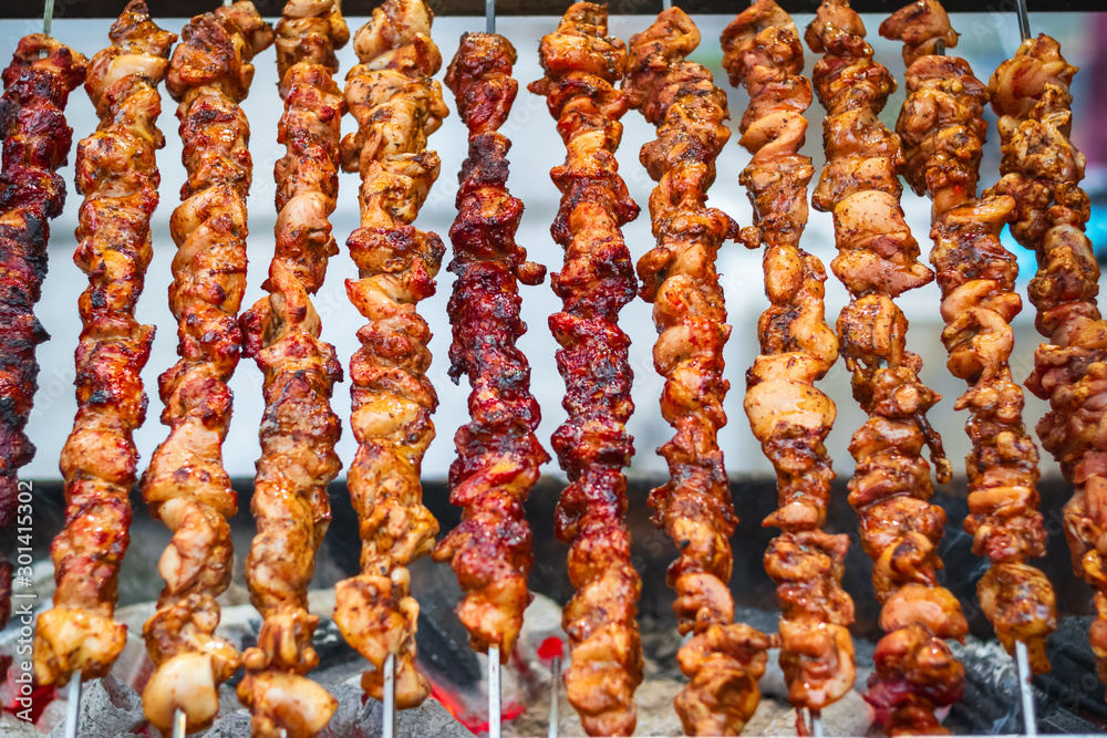  Chicken kebabs cooking on a charcoal grill at Christmas market winter wonderland in London