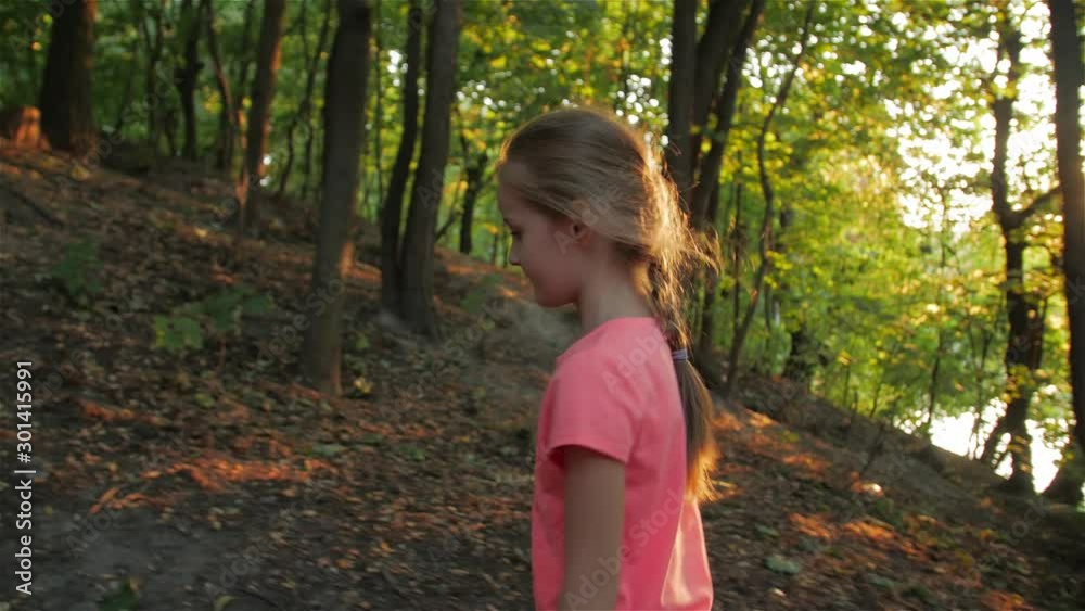 Little girl alone walks park go up evening at sunset blond european caucasian white child 6 years old in pink t shirt sun rays Little girl alone walks park go up evening at sunset blond european caucasian white child 6 years old in pink t shirt sun rays