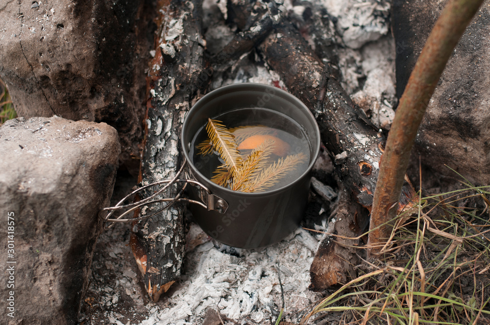 Aromatic and hot herbal tea on campfire Aromatic and hot herbal tea on campfire