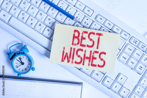Conceptual hand writing showing Best Wishes. Concept meaning an expression of hope for someone s is future happiness or welfare Flat lay above empty note paper on pc keyboard pencils and clock photo