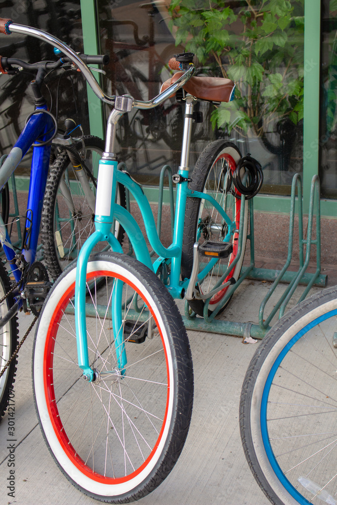 A Trendy Teal Bicycle on an Outdoor Bike Rack