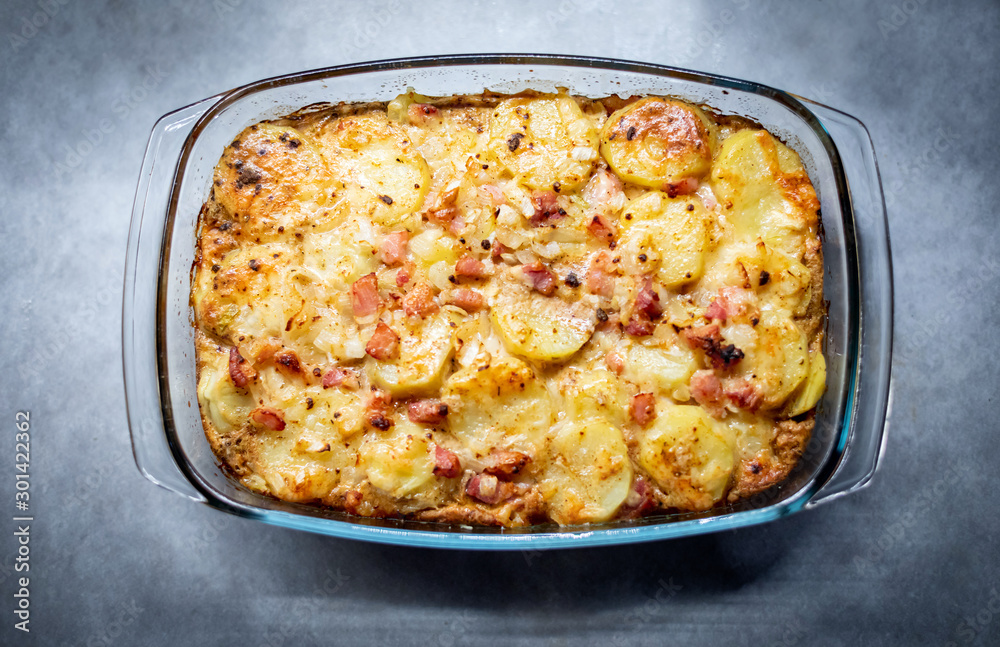 Freshly cooked casserole with potatoes, bacon and cheese close-up on the table top view Freshly cooked casserole with potatoes, bacon and cheese close-up on the table top view