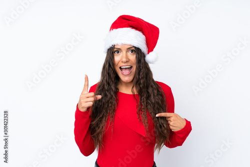 Girl with christmas hat over isolated white background with surprise facial expression