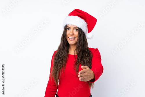 Girl with christmas hat over isolated white background handshaking after good deal