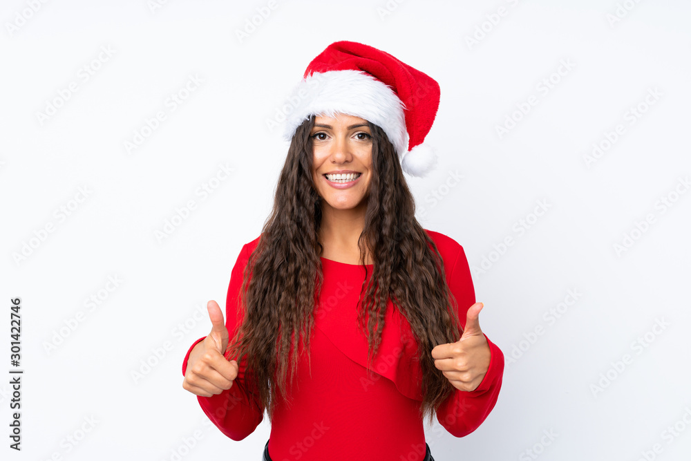Girl with christmas hat over isolated white background giving a thumbs up gesture Girl with christmas hat over isolated white background giving a thumbs up gesture
