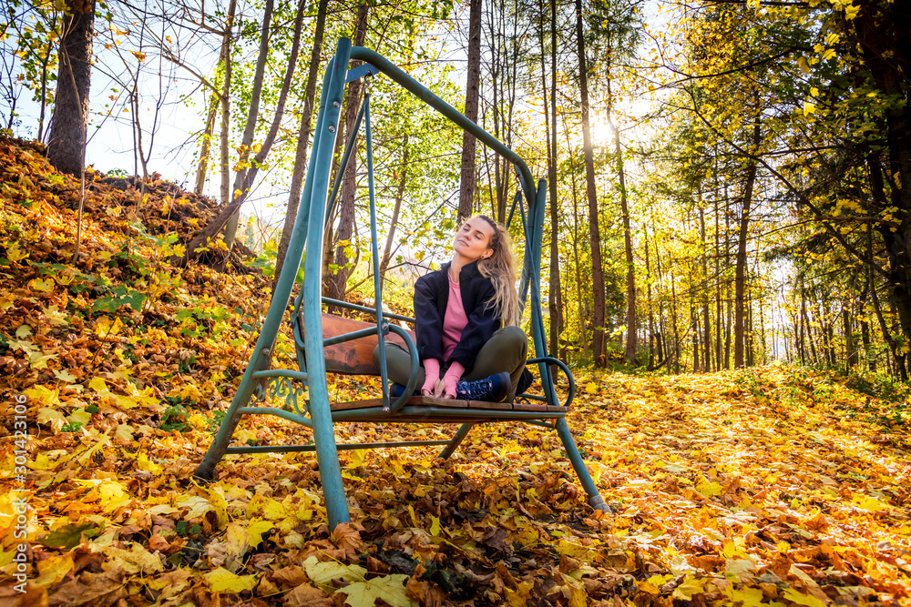 Young woman on swing in beautiful autumn forest Young woman on swing in beautiful autumn forest