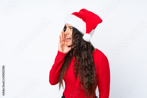 Girl with christmas hat over isolated white background shouting with mouth wide open