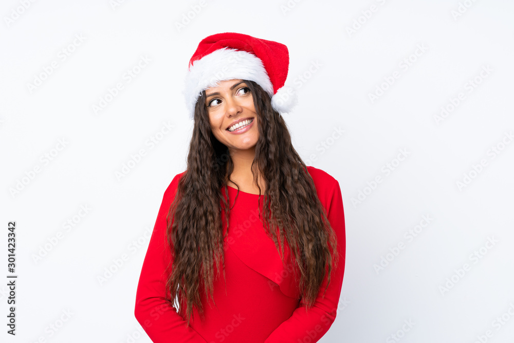 Girl with christmas hat over isolated white background laughing and looking up Girl with christmas hat over isolated white background laughing and looking up
