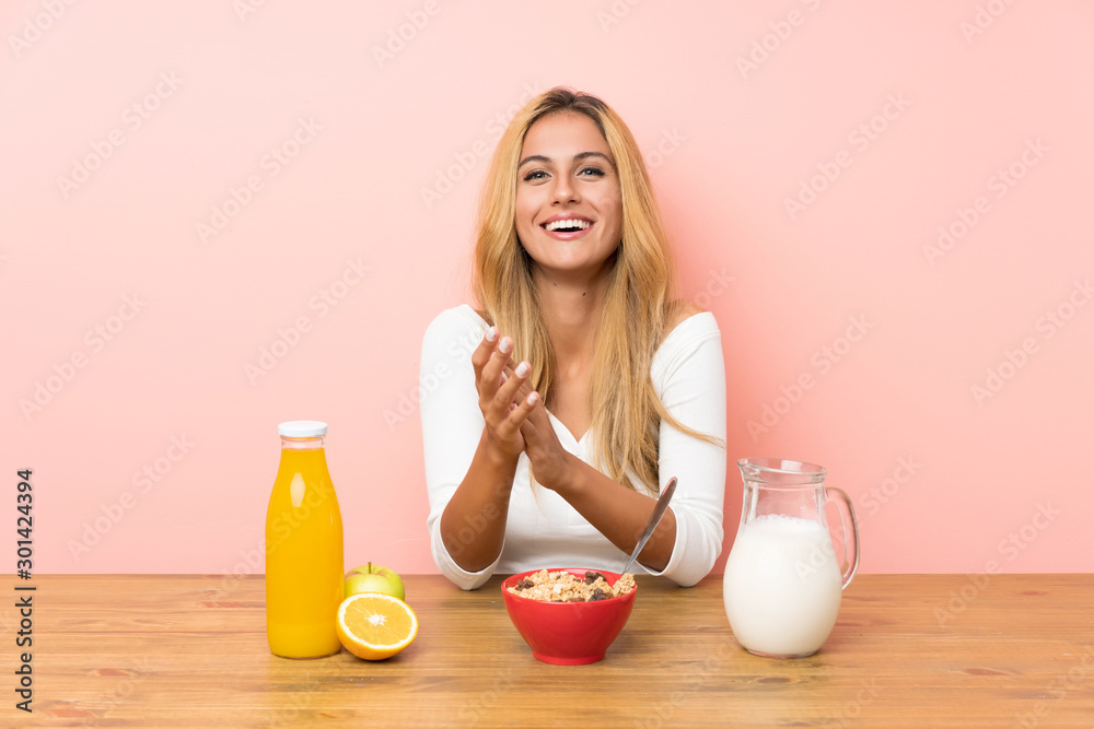 Young blonde woman having breakfast milk applauding Young blonde woman having breakfast milk applauding