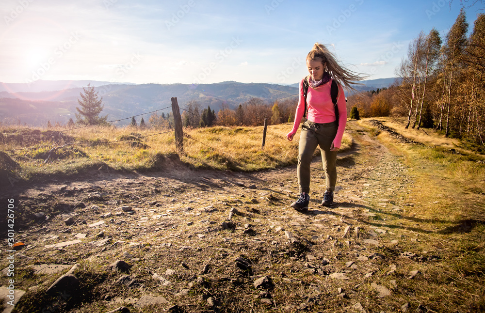 Hiker young woman with backpack rises to the mountain top on mountains landscape background Hiker young woman with backpack rises to the mountain top on mountains landscape background